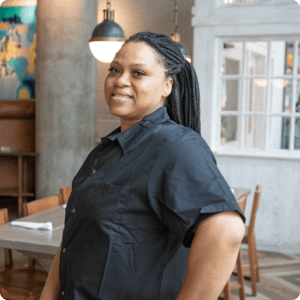 Person smiling in front of a resturant table